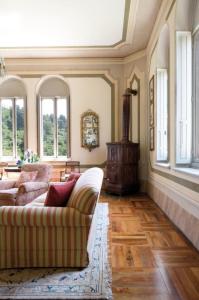 a living room with a couch and windows at Castello di Lispida in Monselice
