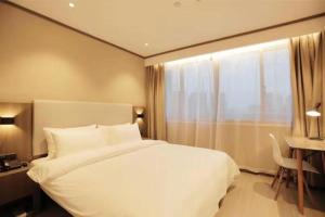 Un pat sau paturi într-o cameră la Hanting Hotel Jinhua Jinyi New Zone