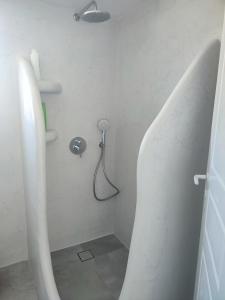 baño con ducha con lavabo y ventilador en Sifnos "Sofia apartments" sea view, en Faros