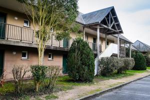 an apartment building with a balcony and a parking lot at Le Bleu Turquoise in Équemauville