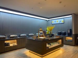 a restaurant with a counter with a display case at Hanting Hotel Jining Jinyu Road in Jining