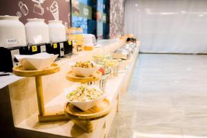 ein Buffet mit Schalen Essen in einem Laden in der Unterkunft Hanting Premium Hotel Ordos Kangbashi Scenic in Ordos