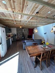 a kitchen and a living room with a wooden ceiling at Yr Ysgubor Converted milking parlour in Llandysul