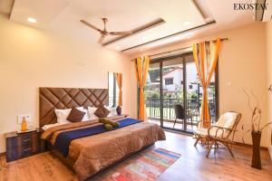 a bedroom with a large bed and a balcony at EKOSTAY- GOLD - Titanium Villa in Lonavala