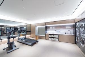 una habitación con gimnasio con cinta de correr y lavadoras en Ji Hotel Ulanhot Wanda Plaza en Ulan Hot