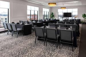 Sala de conferencias con mesas, sillas y TV en Legacy Hotel, Trademark Collection by Wyndham, en Green Bay
