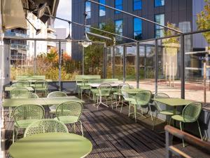 - une rangée de tables et de chaises sur la terrasse dans l'établissement ibis Styles Chatenay Malabry Paris Sud, à Châtenay-Malabry