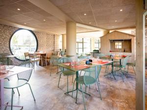 - un restaurant avec des tables et des chaises dans une salle dans l'établissement ibis Styles Chatenay Malabry Paris Sud, à Châtenay-Malabry