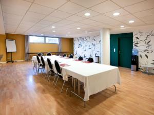 a conference room with a long table and chairs at ibis Styles Chatenay Malabry Paris Sud in Châtenay-Malabry