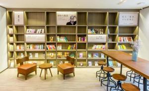 a library with book shelves and a table and chairs at Hanting Hotel Shijiazhuang Shengli Bei Street in Nangaoying