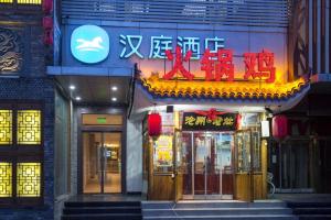 un magasin avec un panneau sur le côté d'un bâtiment dans l'établissement Hanting Hotel Shijiazhuang Shengli Bei Street, à Nangaoying