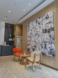 a lobby with two chairs and a table and a painting at Hanting Premium Hotel Shanghai Puqingcheng Zhongxi Road in Qingpu