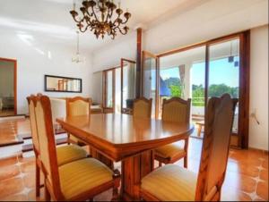 uma sala de jantar com uma mesa de madeira e cadeiras em Villa los Dragos em Santa Ponsa