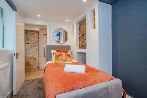 1 dormitorio con 1 cama grande con manta naranja en 2 Bedroom 2Bathroom I Next To Brighton Beach I Sleep 6 en Brighton & Hove