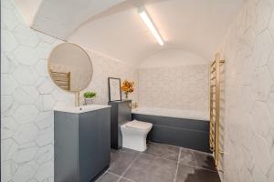 een badkamer met een toilet, een wastafel en een spiegel bij 2 Bedroom 2Bathroom I Next To Brighton Beach I Sleep 6 in Brighton & Hove