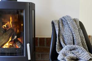 a blanket on a chair next to a fireplace at Tenne in Rietz Neuendorf