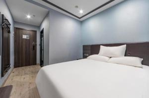 Ein Bett oder Betten in einem Zimmer der Unterkunft Hi Inn Shanghai Jiangpu Park Metro Station