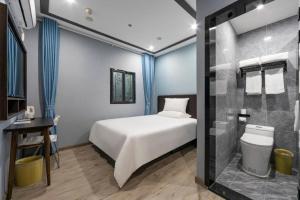 - une chambre avec un lit et une salle de bains pourvue d'une douche dans l'établissement Hi Inn Shanghai Jiangpu Park Metro Station, à Shanghai
