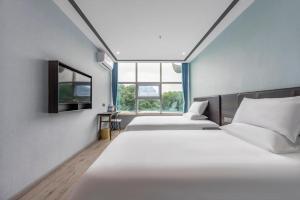 - 2 lits dans une chambre avec 2 fenêtres dans l'établissement Hi Inn Shanghai Jiangpu Park Metro Station, à Shanghai