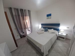 een slaapkamer met een bed met een blauw hoofdeinde bij CASA SIBILLA bi-locale con terrazza a 60 metri dal mare in Marinella