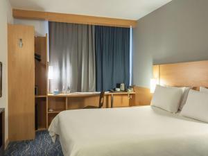 サマラにあるIbis Samaraの大きなベッドとデスクが備わるホテルルームです。