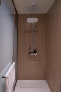 a shower in a bathroom with a toilet and a sink at Ji Hotel Qingdao Shandong Road Mixc in Qingdao