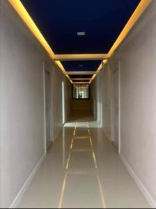 Ban Nong Sai Yong的住宿－RoomQuest Prachin Buri Rojana，建筑里一个空的走廊,有蓝色的天花板
