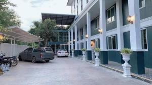 Ban Nong Sai Yong的住宿－RoomQuest Prachin Buri Rojana，停在大楼旁边的停车场的汽车