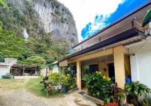 a house with a mountain in the background at RedDoorz Hostel @ Bunakidz Lodge El Nido Palawan in Santa Monica