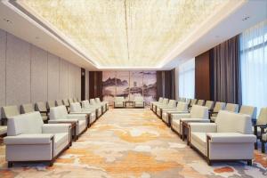a conference room with chairs and a large painting at Song Hotel Jinan Fengming in Hongjialou