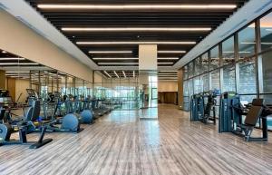 a gym with lots of treadmills and cardio machines at Steigenberger Hotel SUNAC Jinan in Hongjialou