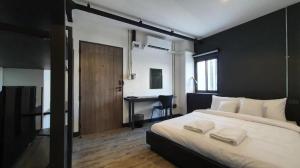 a bedroom with a large bed and a desk at ZK Hotel Chiangmai in Chiang Mai