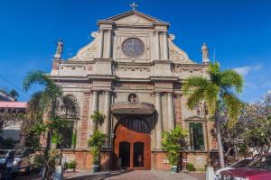 a church with a clock on the front of it at Asia Novo Boutique Hotel-Dumaguete in Dumaguete