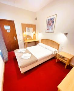 um quarto com 2 camas e um tapete vermelho em COLIBRI em Calella