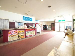 Ein Mann sitzt in einem Wartezimmer in einem Fast-Food-Restaurant. in der Unterkunft Togitsu Yasuda Ocean Hotel in Togitsu