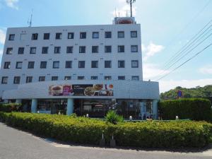 ein großes weißes Gebäude mit einem Restaurant davor in der Unterkunft Togitsu Yasuda Ocean Hotel in Togitsu