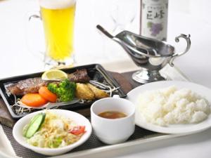 a tray of food with rice and vegetables and a drink at Togitsu Yasuda Ocean Hotel in Togitsu
