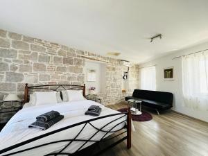Un dormitorio con una pared de piedra y una cama grande. en Dani Apartments, en Split