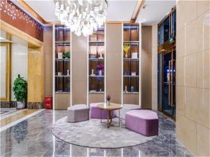 vestíbulo con taburetes púrpura, mesa y lámpara de araña en Lavande Hotel Beijing Shunyi Shimen Metro Station, en Shunyi