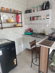a kitchen with white cabinets and a counter top at Kitnets Renascer Beach in Guaibim