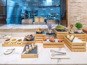 a buffet line with various food items in wooden boxes at Lavande Hotel Tianjin Huayuan in Tianjin