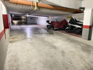 a parking garage with two motorcycles parked in it at City Center R3 in Nerja +17 photos