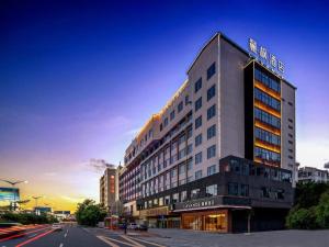 un grand bâtiment dans une rue de la ville avec une rue dans l'établissement Lavande Hotel Chaozhou Fortune Center Lin Street, à Chaozhou
