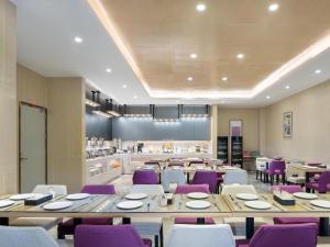 a dining room with tables and purple chairs at Lavande Hotel Jieyang Danpu in Jieyang