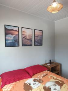 a bedroom with four pictures on the wall at Kitnets Renascer Beach in Guaibim