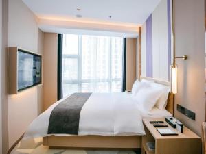 恵州市にあるLavande Hotel Huizhou World Trade Centerのベッドルーム(大型ベッド1台、窓付)