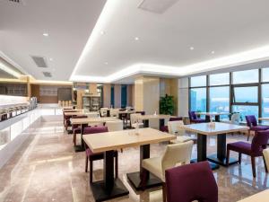 a restaurant with tables and chairs and windows at Lavande Hotel Zunyi Times Tianjie in Zunyi