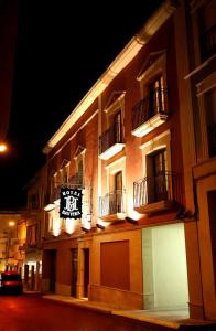 a building with a sign on the side of it at night at Hotel Baviera in Linares