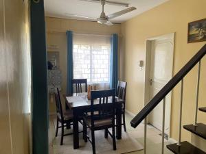 a dining room with a table and chairs and a staircase at Tudor Court in Mombasa