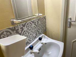 y baño con lavabo blanco y espejo. en Tudor Court en Mombasa